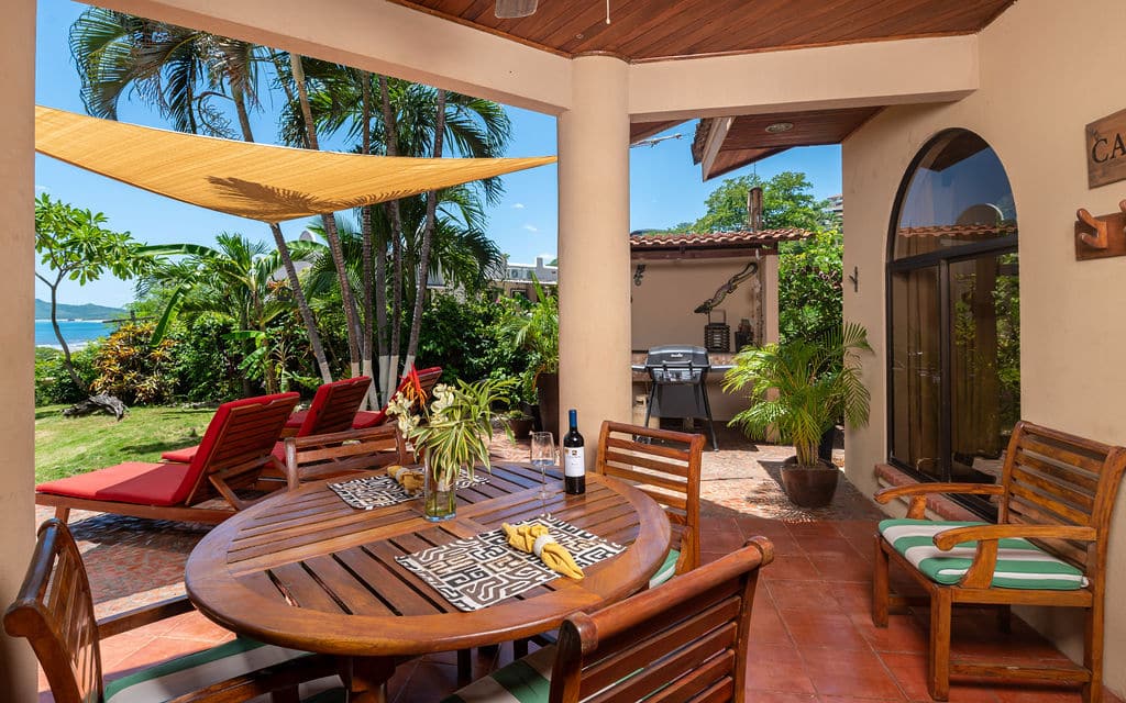 patio with table and sun loungers and ocean view