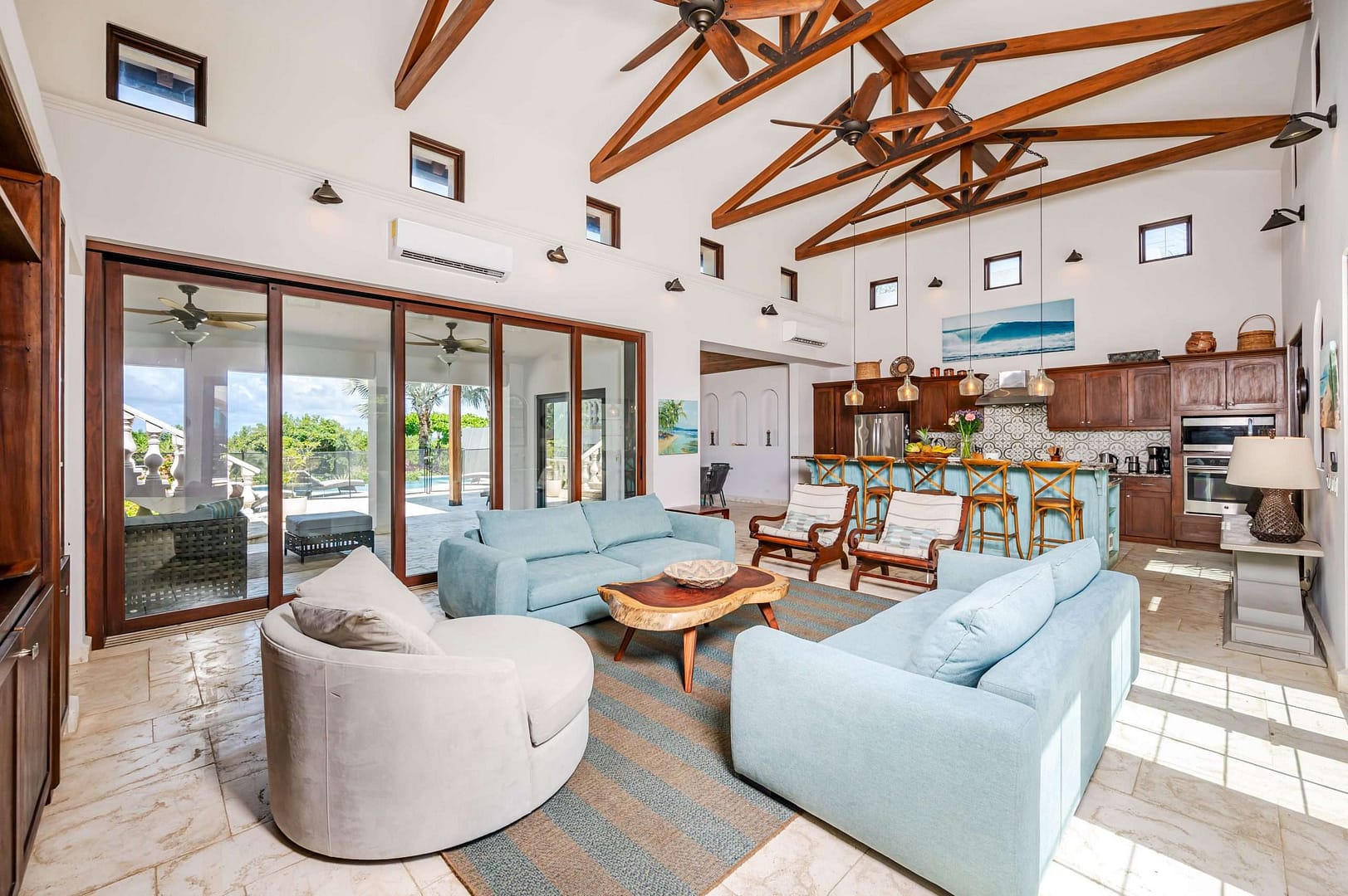 Carolina del Mar living room and kitchen with a view to the outdoor lounge and pool areas.
