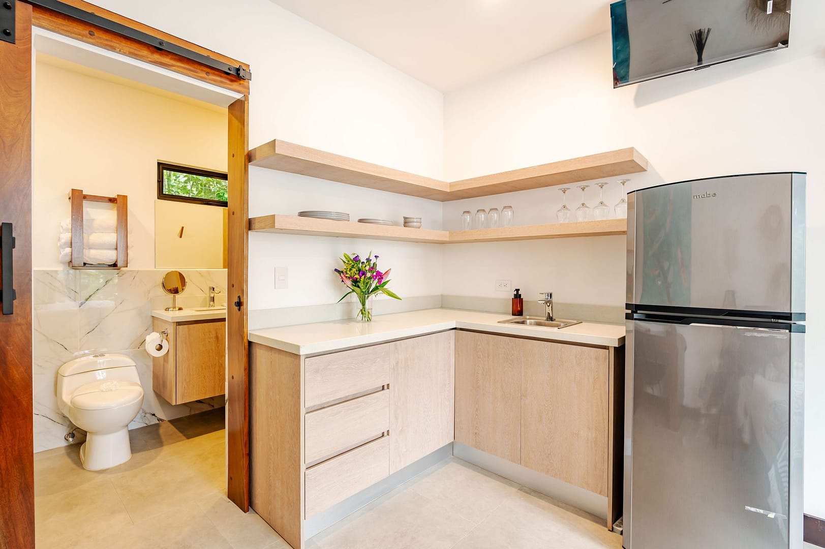 Casita kitchenette with fridge and view of the ensuite bathroom