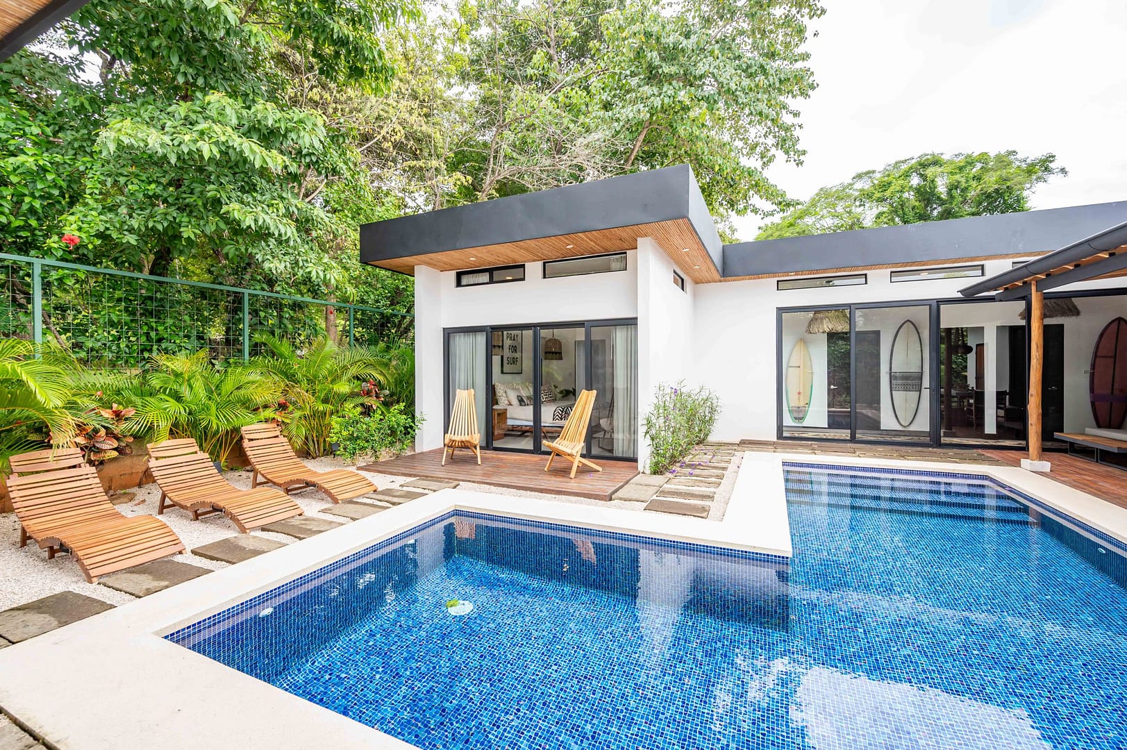View of the Primary bedroom and pool side chairs and sun loungers